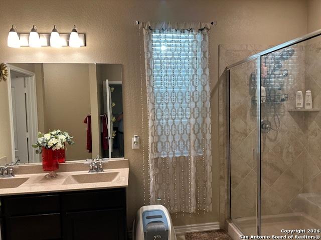 bathroom with vanity and a shower with door