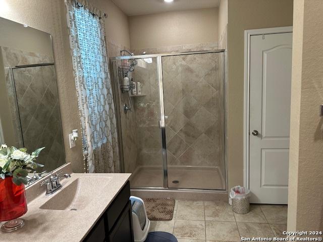 bathroom with vanity, tile patterned floors, and a shower with shower door