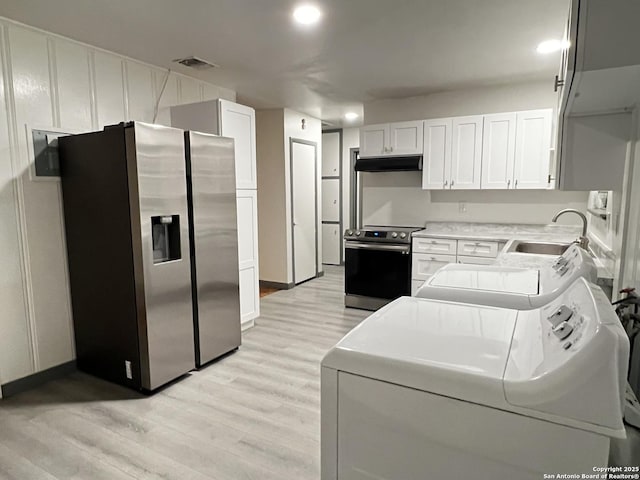 kitchen with sink, separate washer and dryer, light hardwood / wood-style floors, white cabinets, and appliances with stainless steel finishes