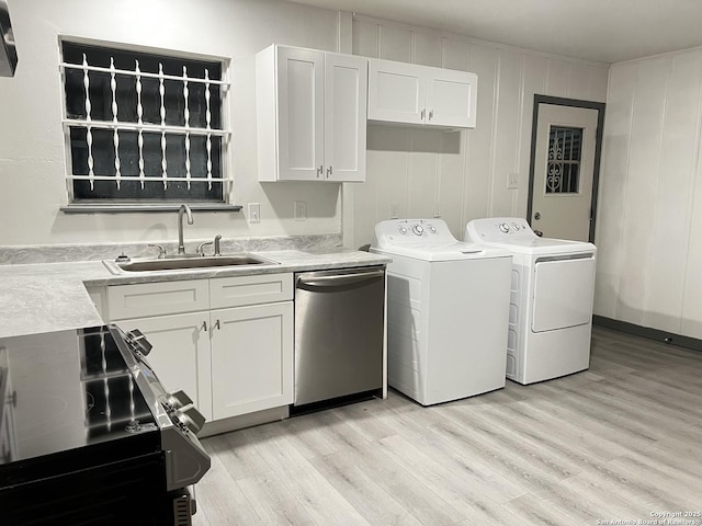 clothes washing area with separate washer and dryer, sink, and light wood-type flooring