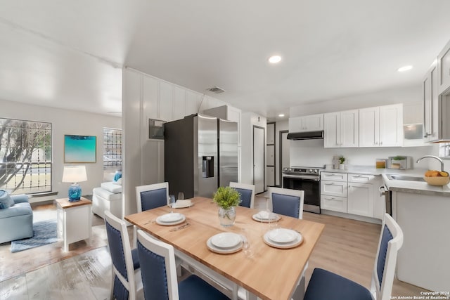 dining space with light hardwood / wood-style flooring and sink