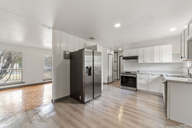 kitchen featuring sink, white cabinets, light hardwood / wood-style flooring, and appliances with stainless steel finishes