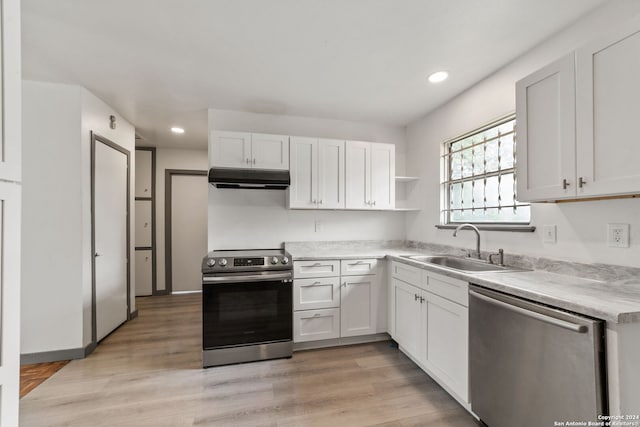 kitchen featuring white cabinetry, sink, stainless steel appliances, and light wood-type flooring