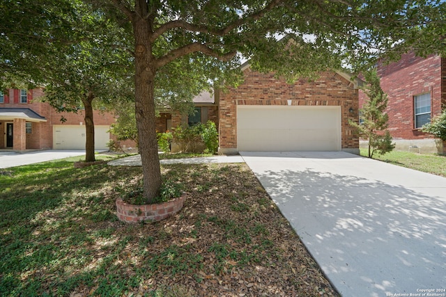 view of front of home with a garage, brick siding, and driveway