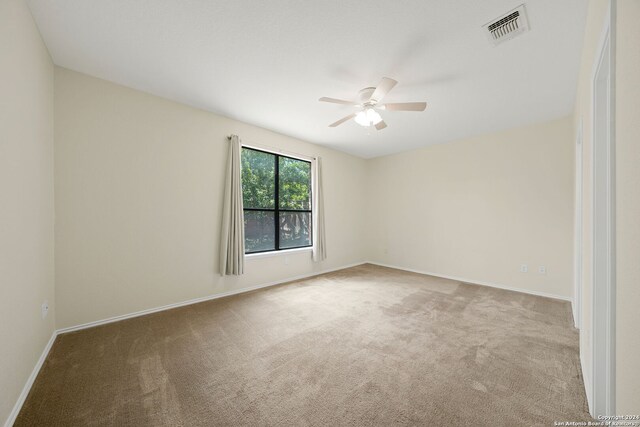 carpeted spare room featuring ceiling fan