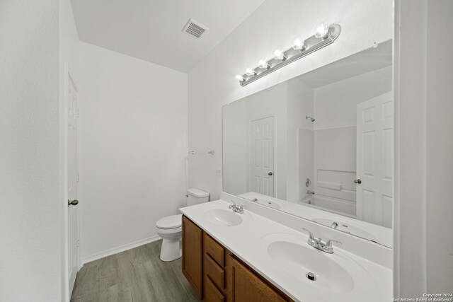 bathroom featuring hardwood / wood-style flooring, dual vanity, and toilet