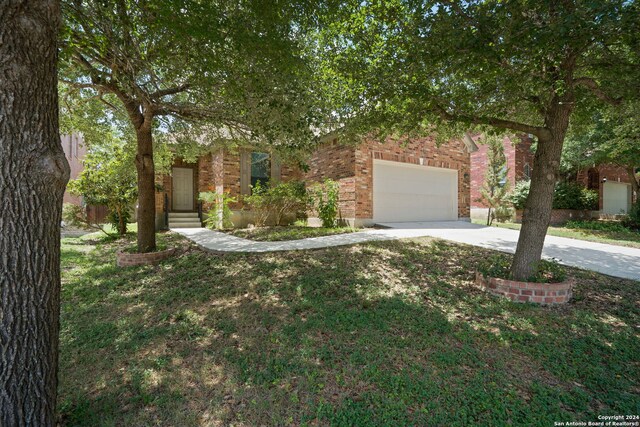 obstructed view of property featuring a garage and a front lawn