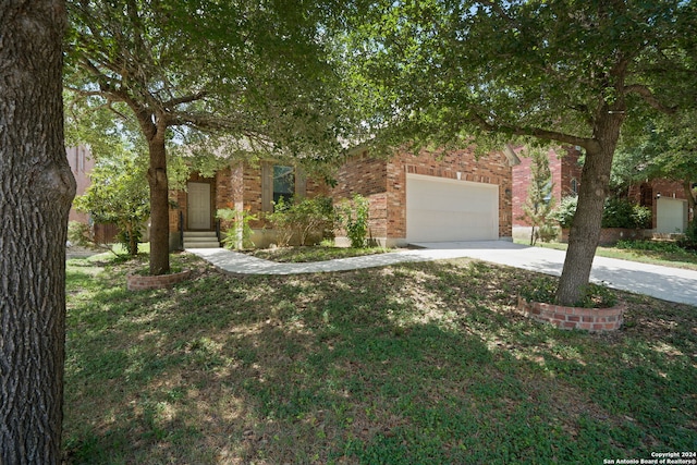 view of front of property with a garage, driveway, brick siding, and a front lawn