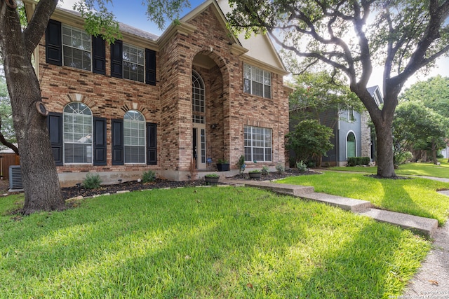 view of front of home featuring central air condition unit and a front yard