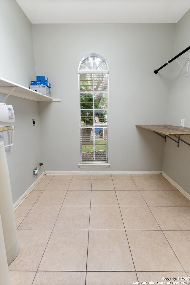 clothes washing area featuring electric dryer hookup, hookup for a gas dryer, and light tile patterned floors