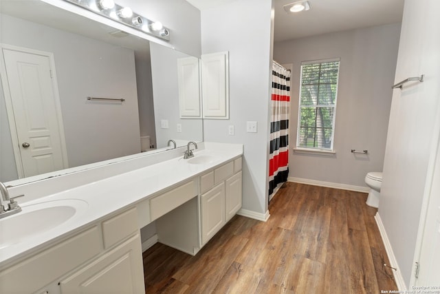 bathroom featuring vanity, wood-type flooring, and toilet