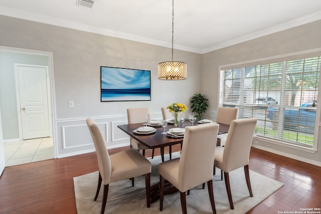 dining space featuring wood-type flooring and ornamental molding