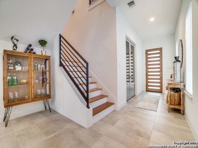 stairway with light tile patterned floors