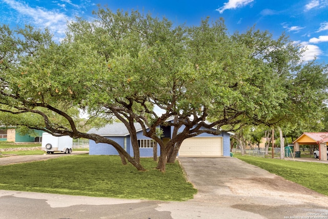 obstructed view of property featuring a garage and a front lawn