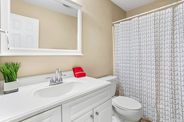 bathroom with a textured ceiling, vanity, toilet, and curtained shower