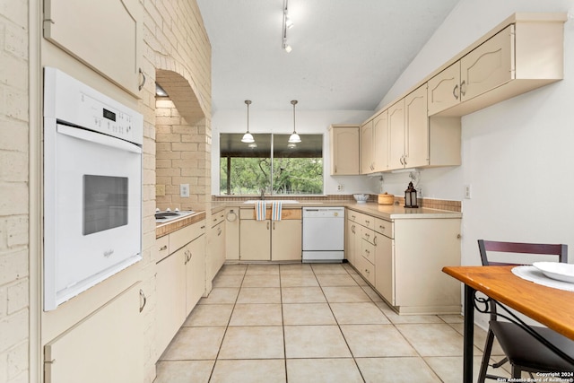 kitchen with light tile patterned floors, hanging light fixtures, white appliances, and cream cabinetry