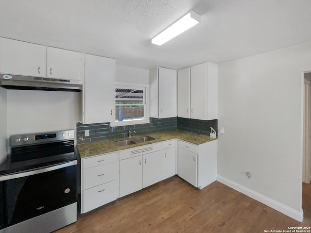 kitchen featuring sink, stainless steel electric stove, decorative backsplash, white cabinetry, and hardwood / wood-style flooring