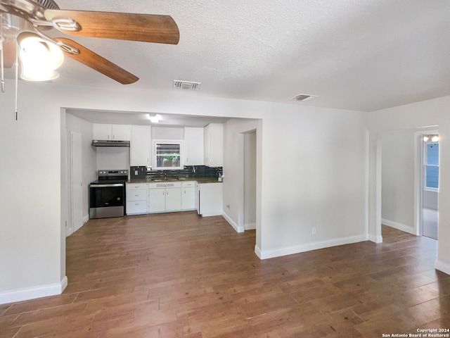 kitchen with wood-type flooring, ceiling fan, tasteful backsplash, white cabinets, and stainless steel range with electric stovetop