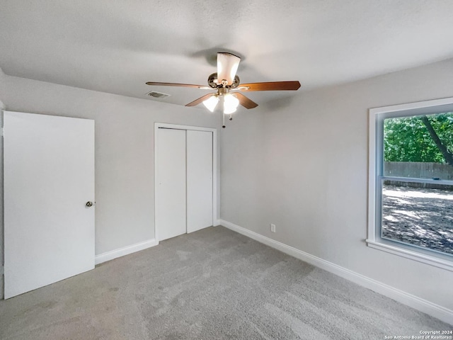unfurnished bedroom featuring carpet floors, ceiling fan, and a closet