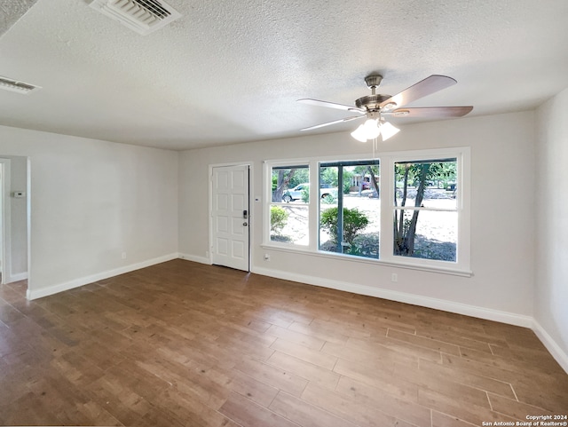 unfurnished room with a textured ceiling, hardwood / wood-style flooring, and ceiling fan