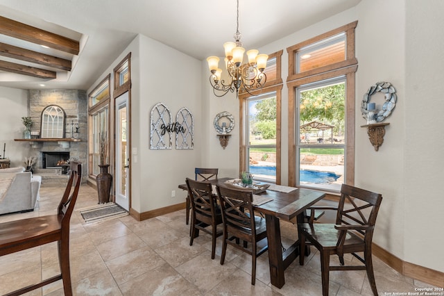 tiled dining space featuring beamed ceiling, an inviting chandelier, and a fireplace