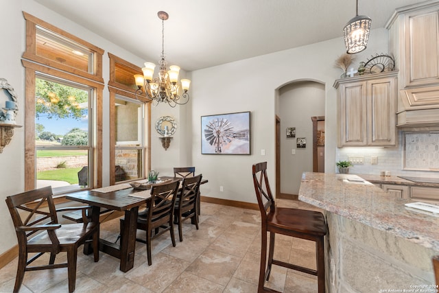 dining space featuring light tile patterned flooring and a notable chandelier