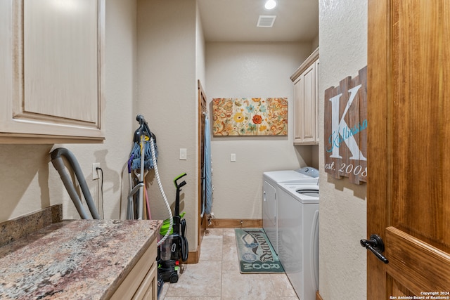 laundry room featuring cabinets, washing machine and dryer, and light tile patterned floors