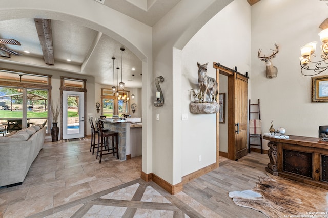 hallway with an inviting chandelier, a barn door, a textured ceiling, and hardwood / wood-style flooring