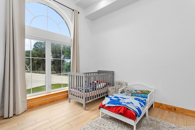 bedroom with hardwood / wood-style flooring and multiple windows