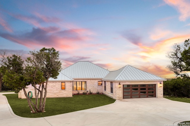 modern inspired farmhouse with a garage and a yard