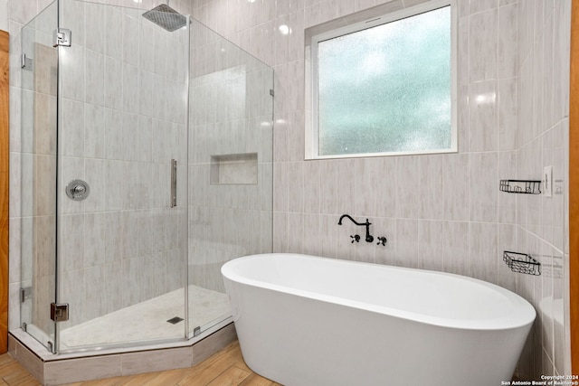 bathroom with plus walk in shower, tile walls, and hardwood / wood-style flooring