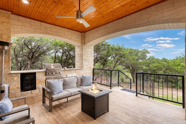 wooden deck featuring ceiling fan, an outdoor living space, an outdoor kitchen, and a grill