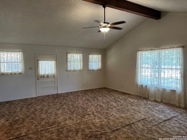 spare room featuring a healthy amount of sunlight, vaulted ceiling with beams, carpet floors, and ceiling fan