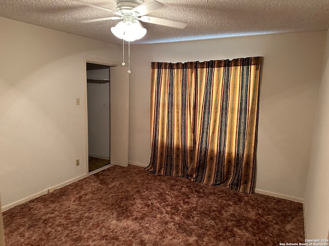 carpeted spare room featuring a textured ceiling and ceiling fan