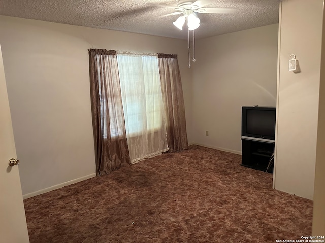 empty room with carpet, ceiling fan, a healthy amount of sunlight, and a textured ceiling