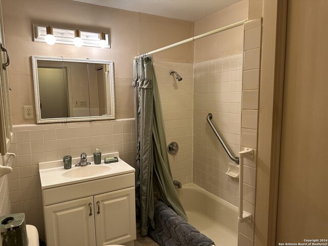 bathroom featuring tile walls, vanity, and shower / bath combination with curtain