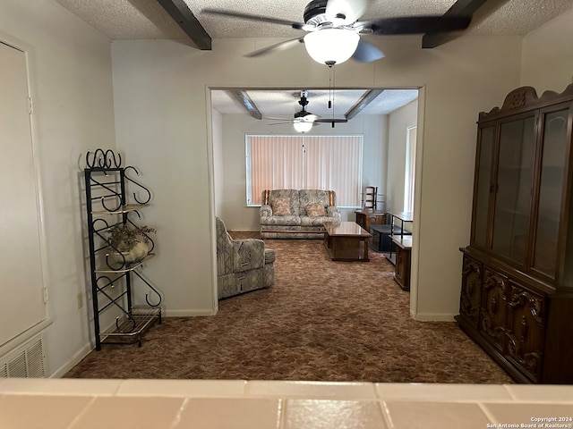 living room featuring beamed ceiling, a textured ceiling, dark colored carpet, and ceiling fan