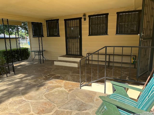 view of exterior entry with a patio