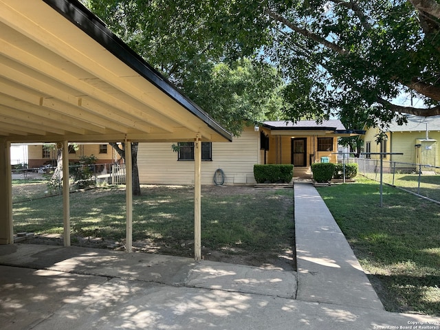 view of property's community with a carport and a lawn