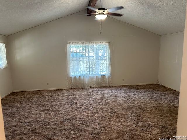 empty room with carpet flooring, a textured ceiling, lofted ceiling, and ceiling fan