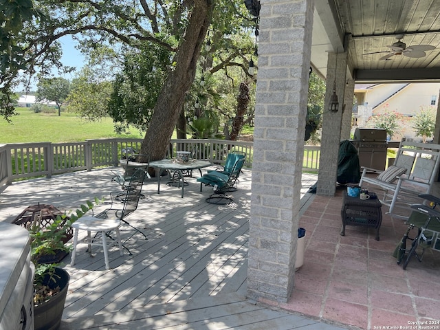 deck with a yard and a ceiling fan