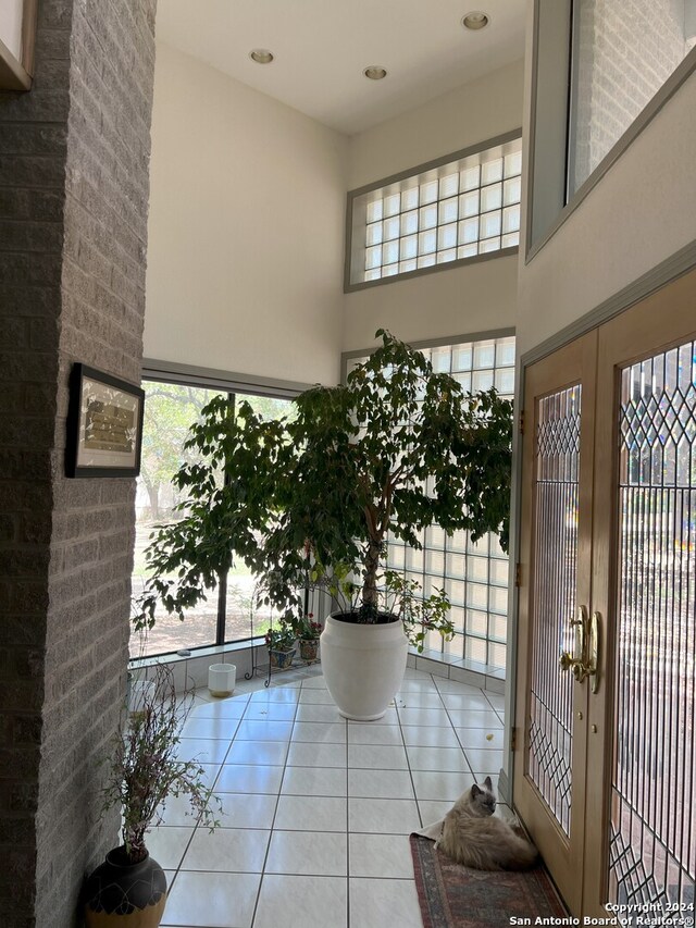 tiled entryway with french doors and a towering ceiling