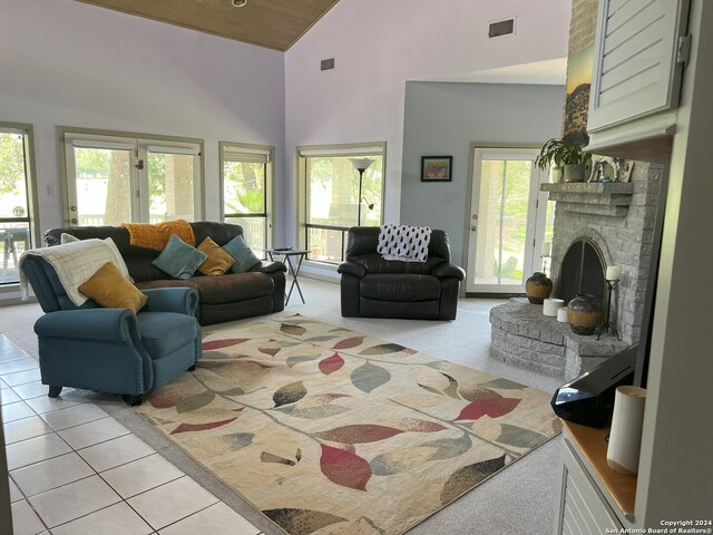 living room with high vaulted ceiling, light tile patterned floors, and a brick fireplace