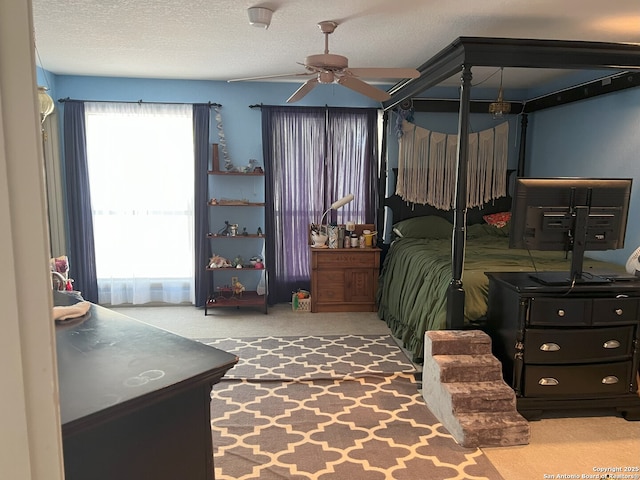 carpeted bedroom with a textured ceiling and ceiling fan