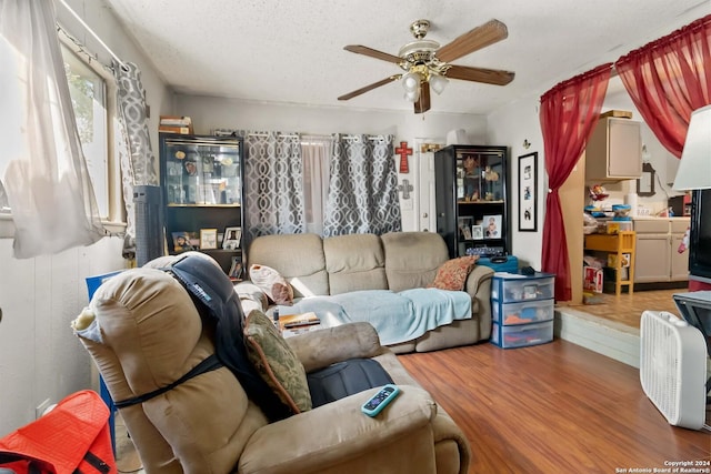 living room featuring a textured ceiling, ceiling fan, and hardwood / wood-style flooring