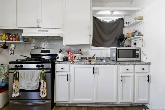 kitchen featuring stainless steel appliances, white cabinets, tasteful backsplash, and sink