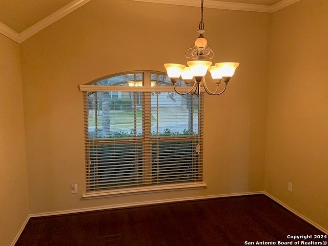 unfurnished room featuring a notable chandelier, vaulted ceiling, ornamental molding, and hardwood / wood-style floors