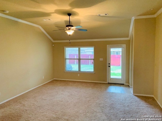 empty room featuring ornamental molding, lofted ceiling, light colored carpet, and ceiling fan