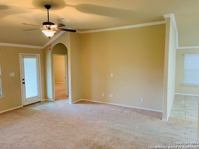 carpeted empty room with crown molding, ceiling fan, and lofted ceiling