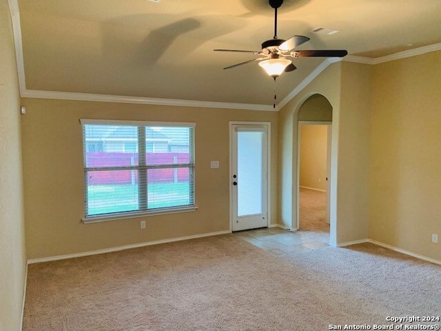 carpeted spare room featuring ornamental molding, ceiling fan, and vaulted ceiling